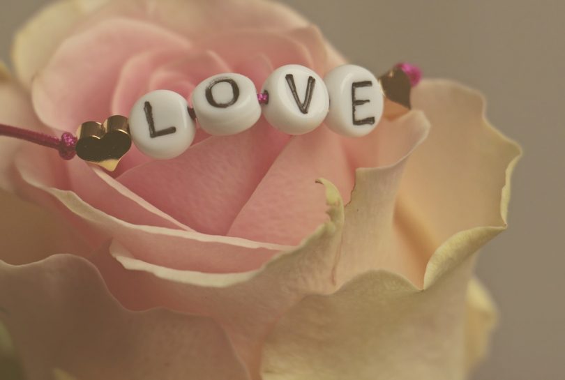 Rosa amb un braçalet amb la paraula LOVE