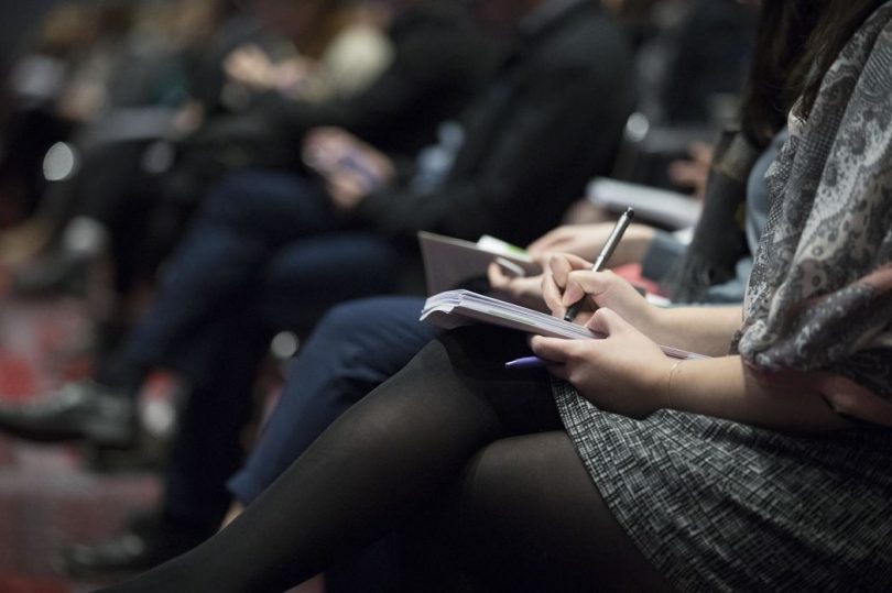 Estudiant prenent apunts en una xarrada informativa