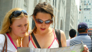 two ladies with sunglasses looking at map of the city