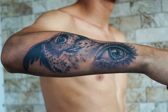 man with eagle and eye tattooed on arm