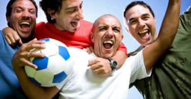 four happy men with football