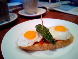 Pincho of two fried eggs and a spicy pepper