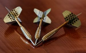 three darts on a wooden table