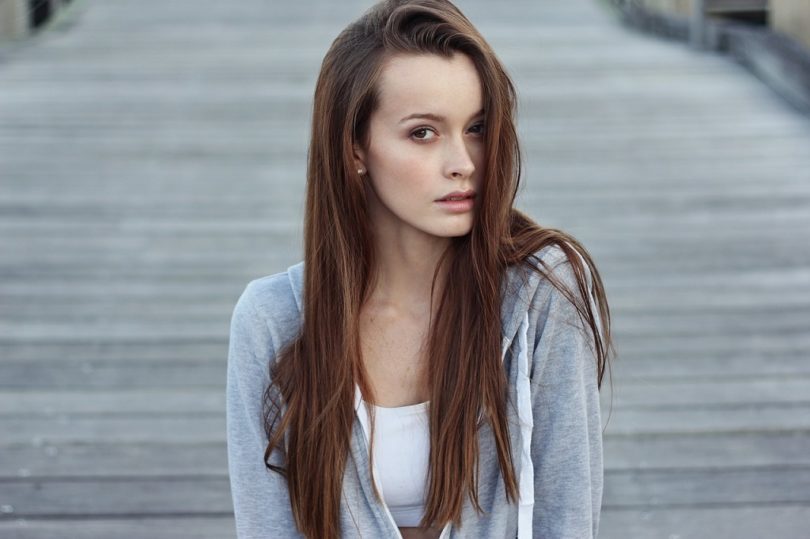 lady with brown hair in white top and grey vest