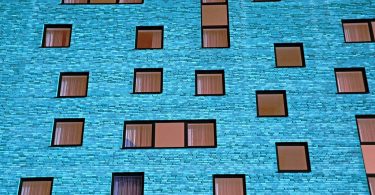 blue apartment building with uneven windows