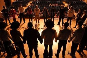 group in circle on stage in theatre