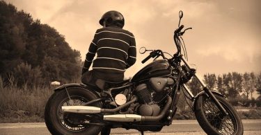 man sitting sideways on motorcycle