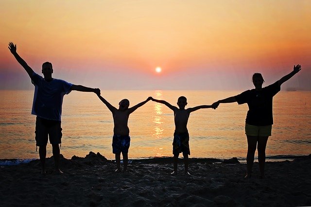 family on beach at sunset