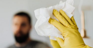 yellow cleaning glove wiping mirror