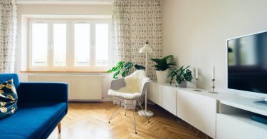 salón moderno con sofá azul y butaca blanca