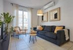 Salón de un apartamento, donde en la parte superior central se distingue un aparato de aire acondicionado.