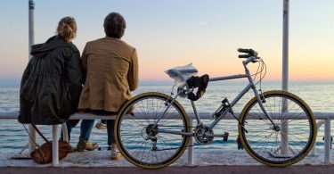 velo posé avec deux personnes face à la mer
