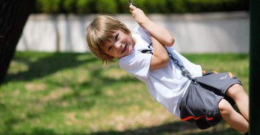 enfant blond sur balancoire