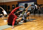 deux personnes s'étirant dans une salle de gym