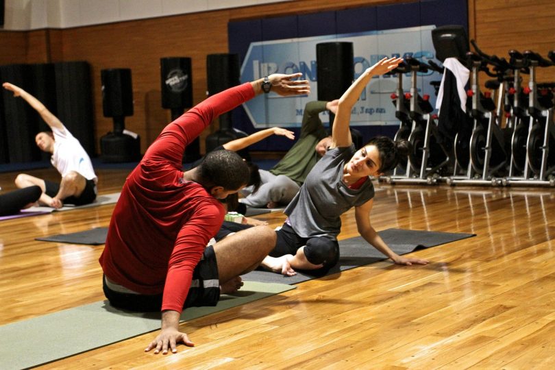 deux personnes s'étirant dans une salle de gym