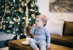 Niño comiendo sobre la mesa con árbol de navidad de fondo