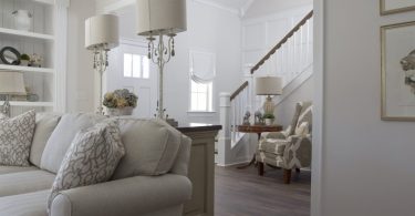 salon avec meubles blancs et escalier