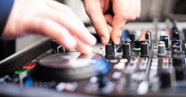 mains de dj sur une console de musique
