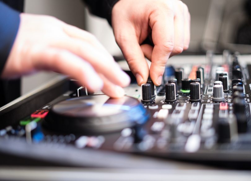 mains de dj sur une console de musique