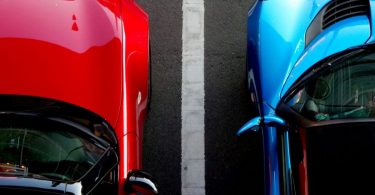 voiture rouge et voiture bleue le long d'une bande blanche