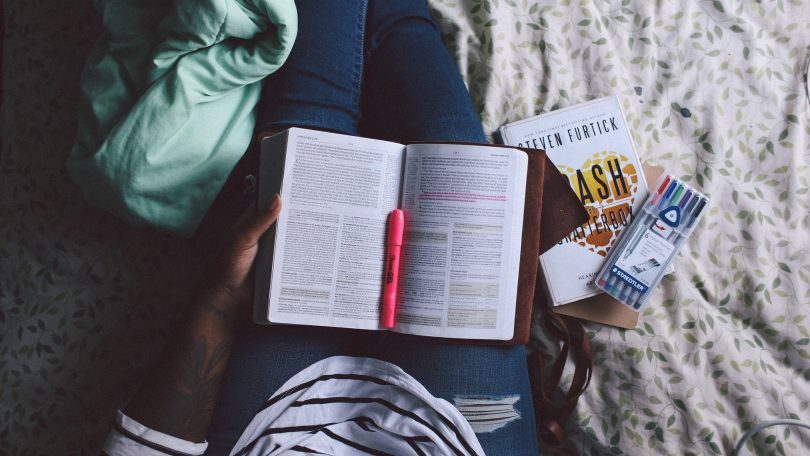 livre ouvert sur les jambes d'une femme dans un lit