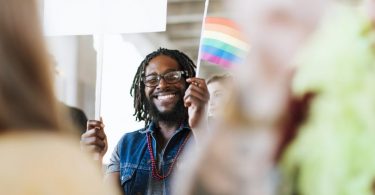 homme tenant un drapeau gay