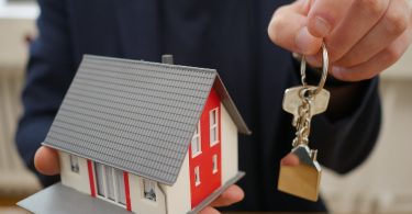 main tenant des clés de maison sur une porte