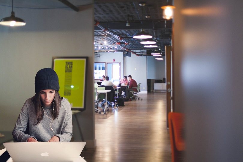 femme travaillant devant un ordinateur dans un bureau ouvert