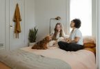 deux femmes assises dans une chambre avec un chien