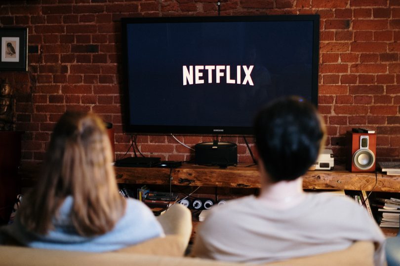 Couple assis dans un canapé regardant la tv