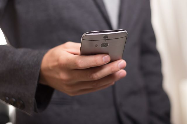 Empresari consultant el seu telèfon mòbil