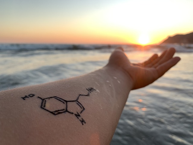 arm with tattoo near water