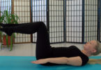 blonde lady doing pilates exercise on mat
