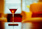 vermouth in glass on bar with orange chair in background