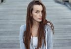 lady with brown hair in white top and grey vest