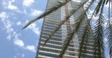 exterior apartment building with blue sky and palm tree