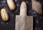 black table with baguette and whole grain bread