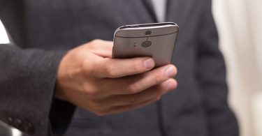 man in suit looking at phone