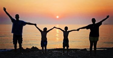 family on beach at sunset