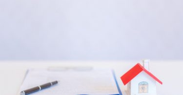 papers and little house with red roof