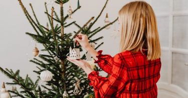 lady decorates christmas tree