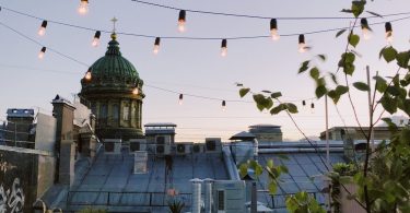 Un balcón decorado con luces en el texto y el atardecer