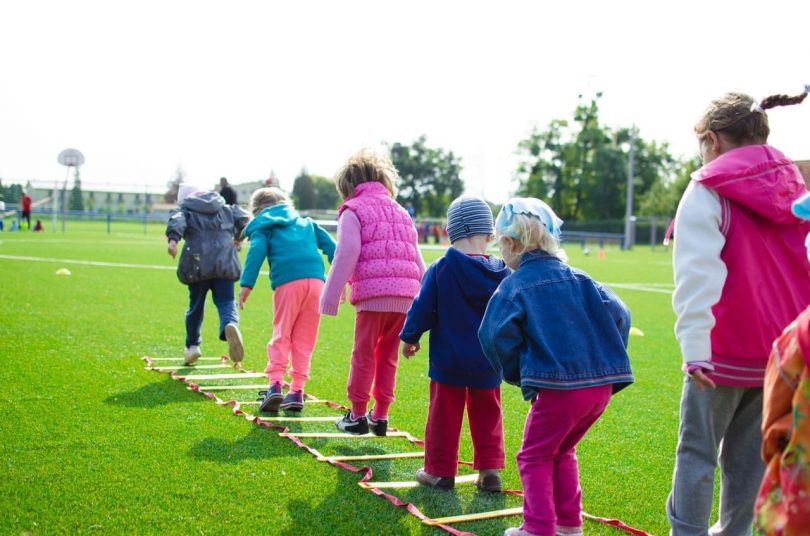 Une équipe d'enfants jouant sur l'herbe verte