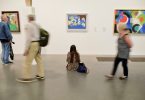 personnes regardant des oeuvres au musée