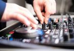 mains de dj sur une console de musique