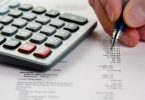maint tenant un crayon sur une feuille de calcul avec calculatrice