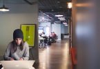 femme travaillant devant un ordinateur dans un bureau ouvert