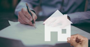 signature de document devant une main tenant une maison